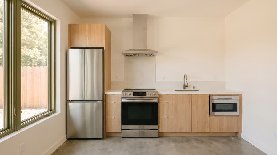 CADU interior showing the mid-tier package with a counter-depth fridge and a panelled dishwasher.