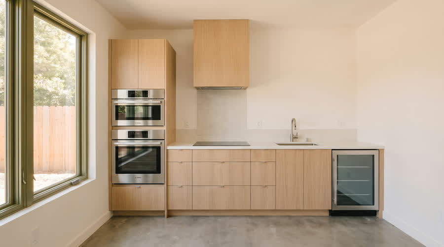 CADU interior showing the fully integrated package, with appliances hidden behind oak panels.